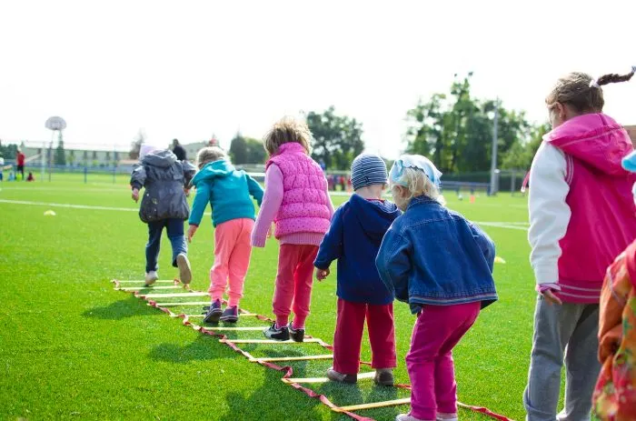 Children jumping into the rungs of a ladder