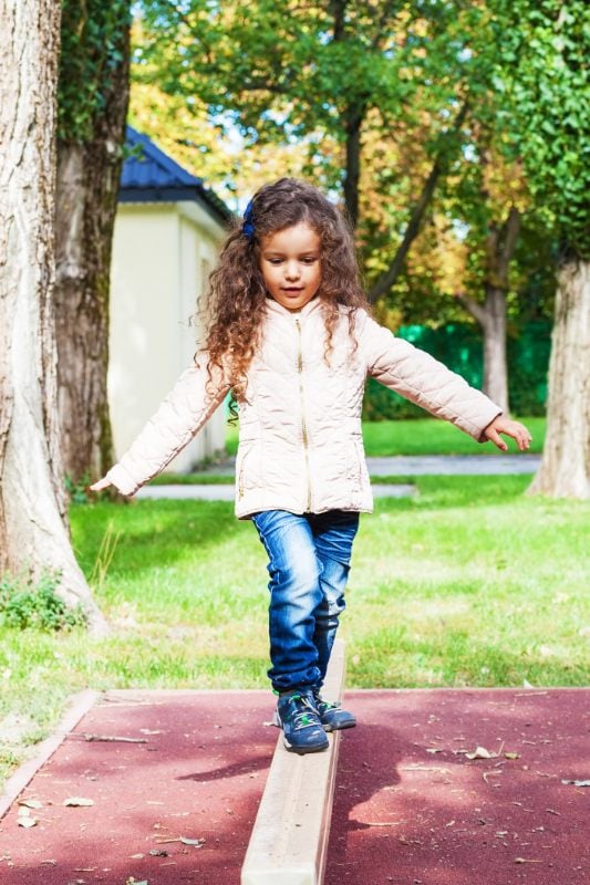 Child walking along balancing beam