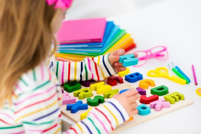 Child playing with an alphabet puzzle