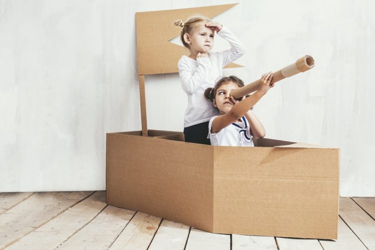 children engaging in symbolic play with boxes