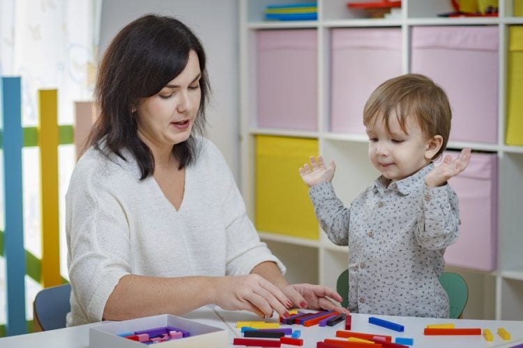 teacher counting blocks with child