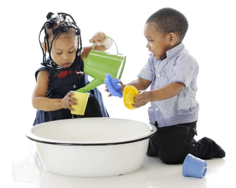 Children playing with water in a trough