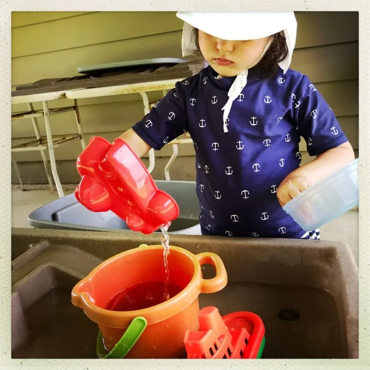 Child learning about volume and capacity with water play