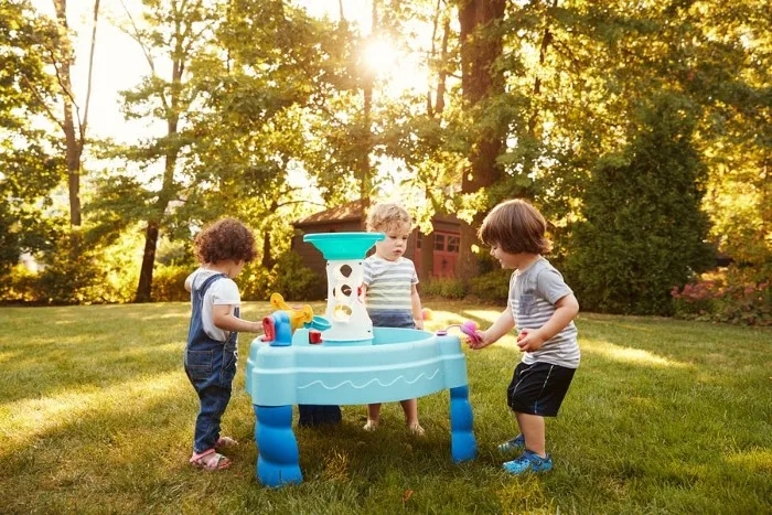 Children engaging in water play at a water table 