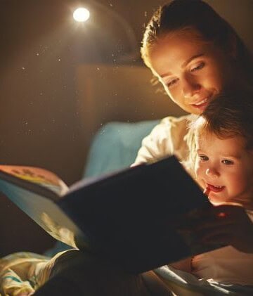 Mother and child on bed reading a story together