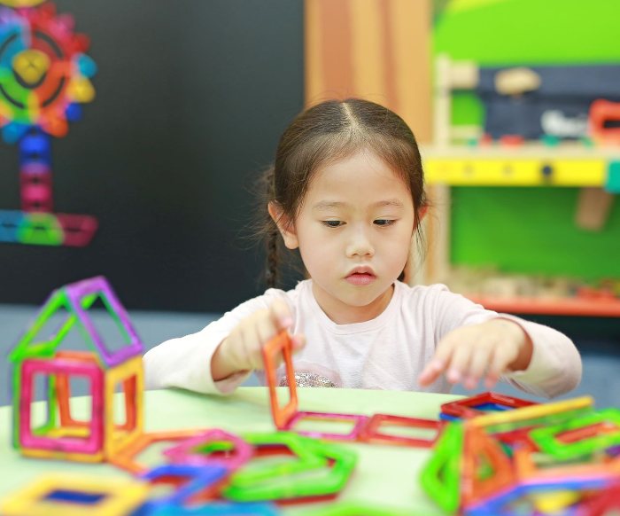 Girl playing with magnetic construction toys