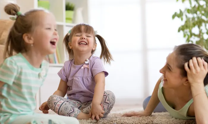 Children laughing with their mother while playing a vocabulary game