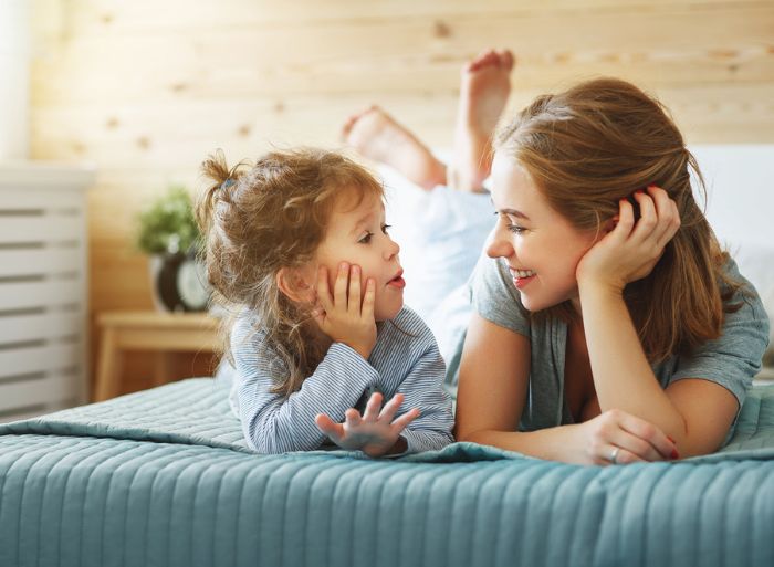 Mother and daughter playing a game on the bed