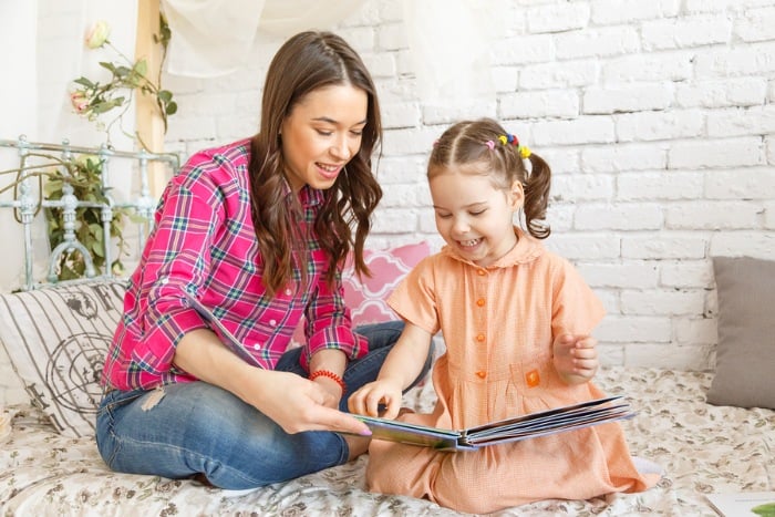 Mother and daughter paging through book together