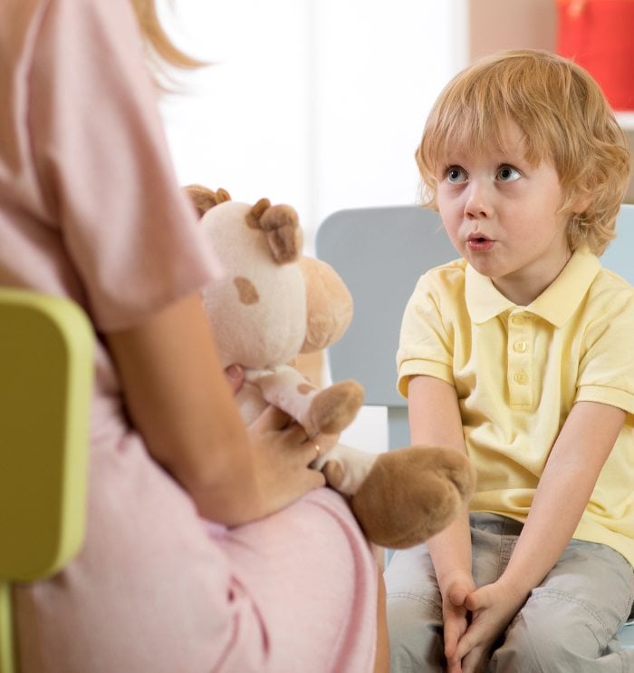 Speech therapist working with young boy