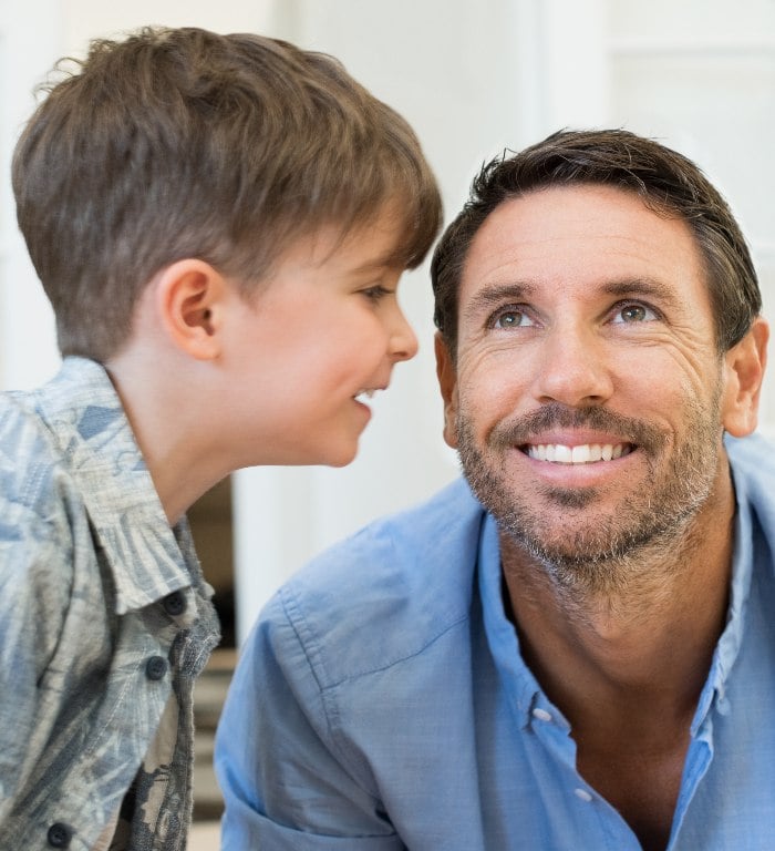 Son telling his father something in his ear