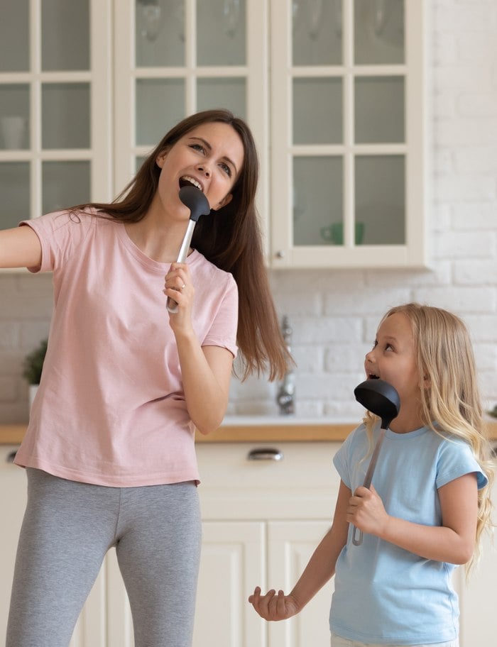 Mom and daughter singing in kitchen