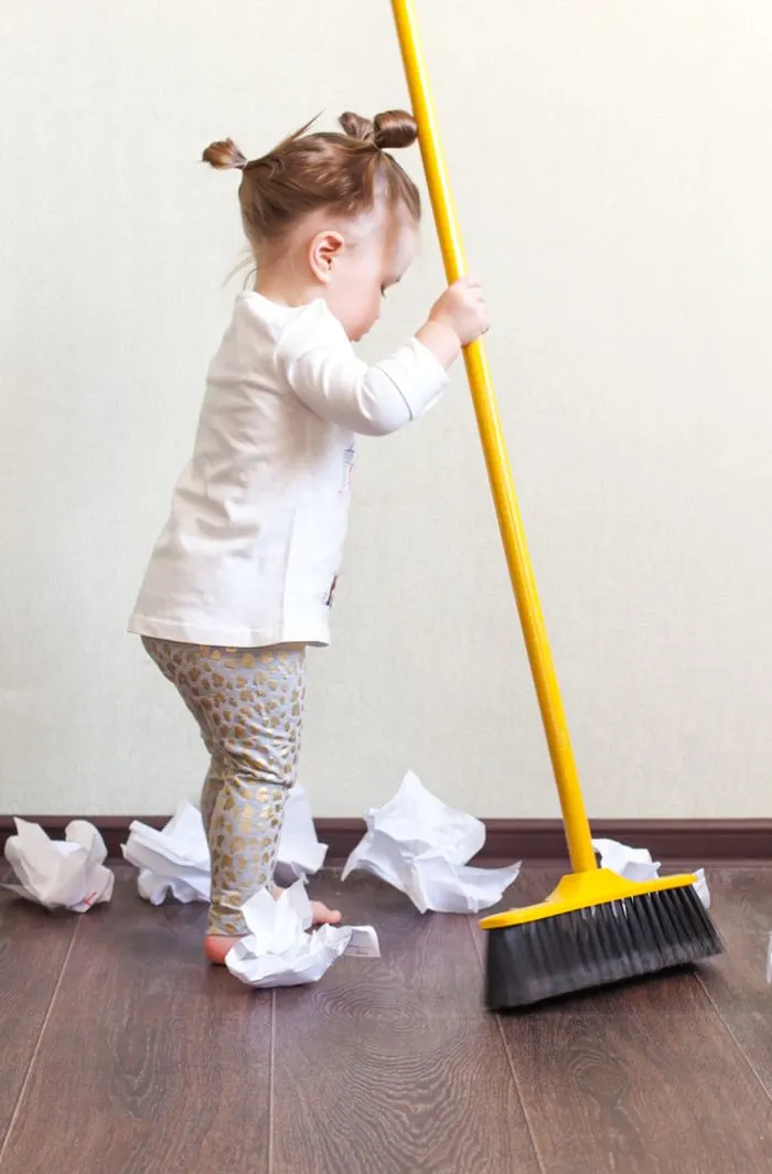 Child sweeping the floor.