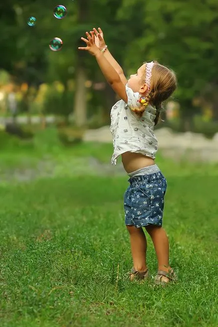 Child trying to catch bubbles