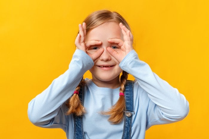 Child doing Grandmother's glasses rhyme