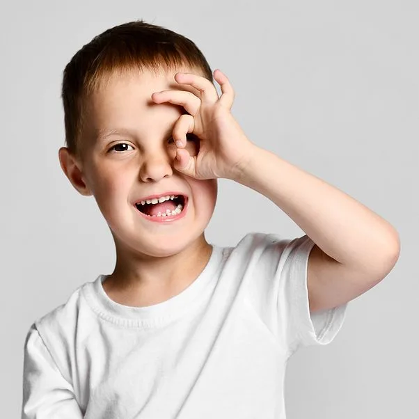 Little boy imitating a spyglass with his fingers. 