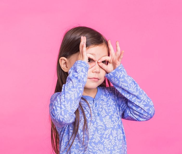 Child pretending to make glasses with fingers