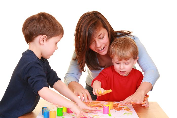 Mother and sons finger painting together