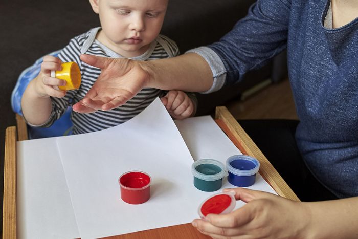 Mom and son finger painting on paper