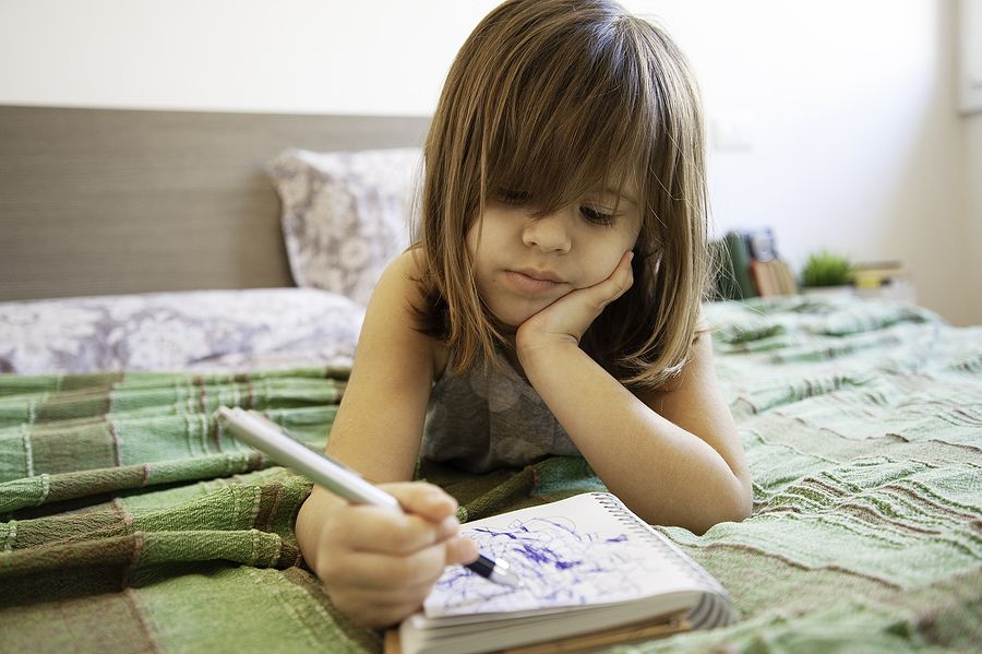 Child scribbling in notebook