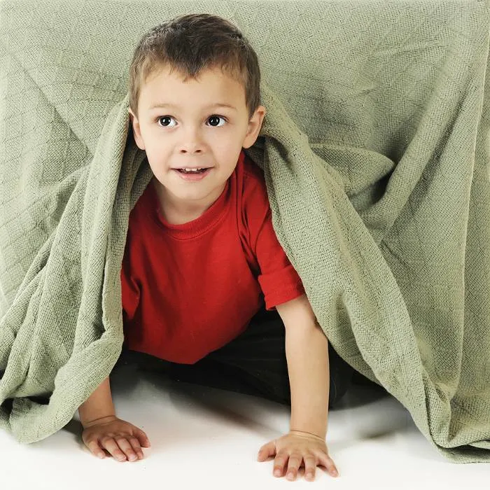 Child crawling under sheet