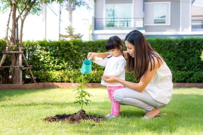 Image of Child playing in garden watering plants