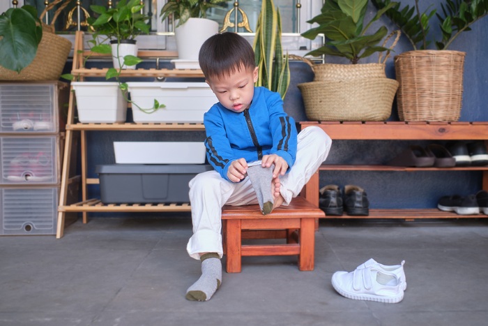 Child putting on shoes and socks