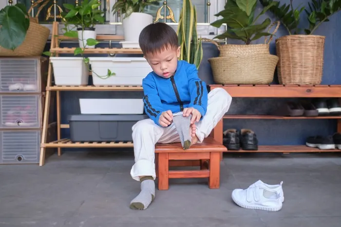 Child putting on shoes and socks