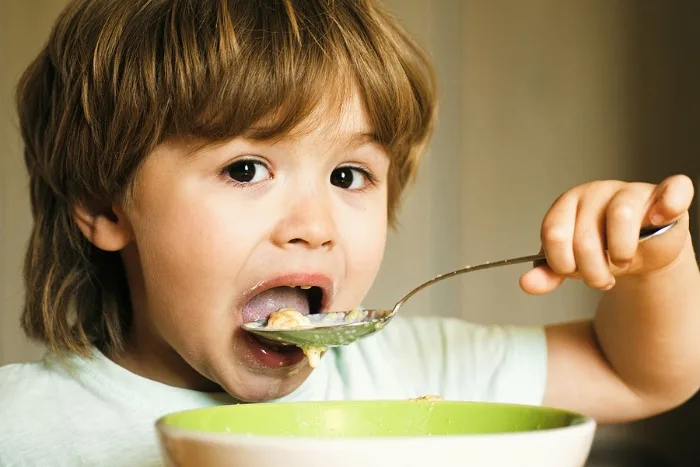 Child eating cereal with a spoon