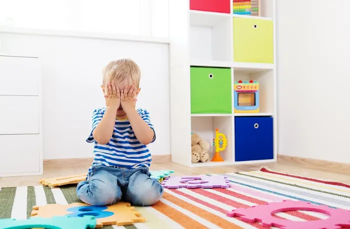Preschooler on ground closing eyes to follow directions