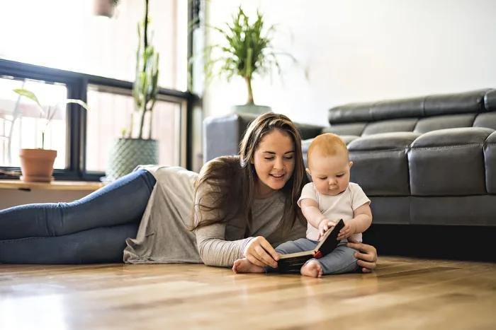 Mother paging through book with young child.