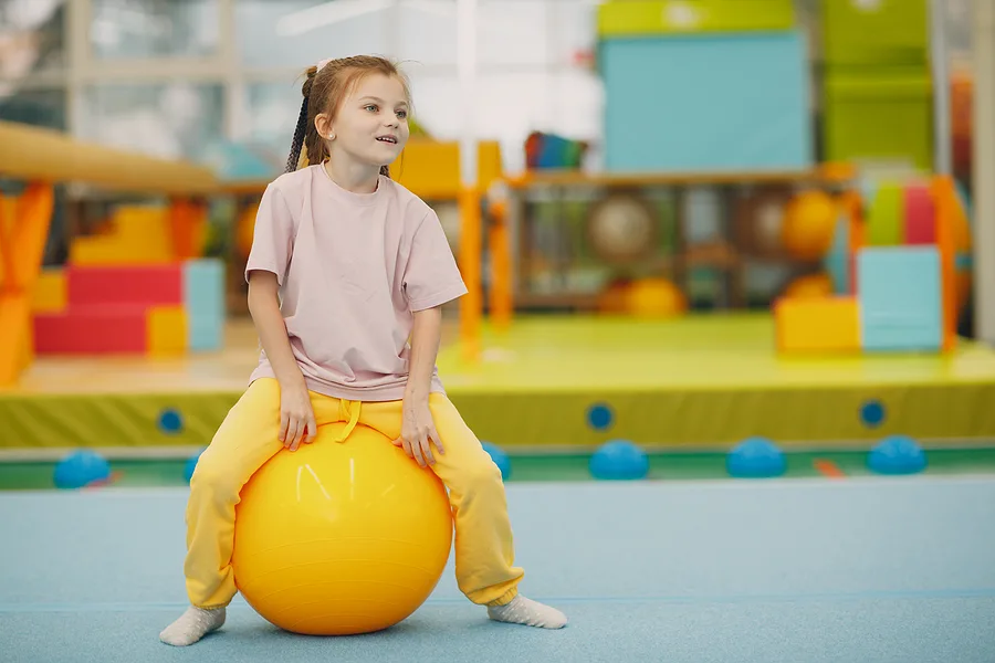 Preschooler balancing while sitting on exercise ball 
