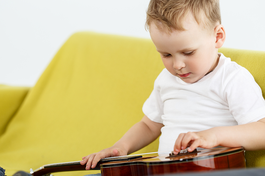 Preschooler playing an ukulele