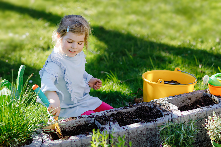 Child using a shovel in the garden.