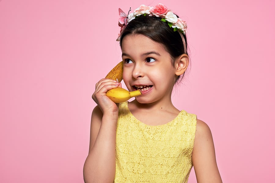 child pretending a banana is a phone