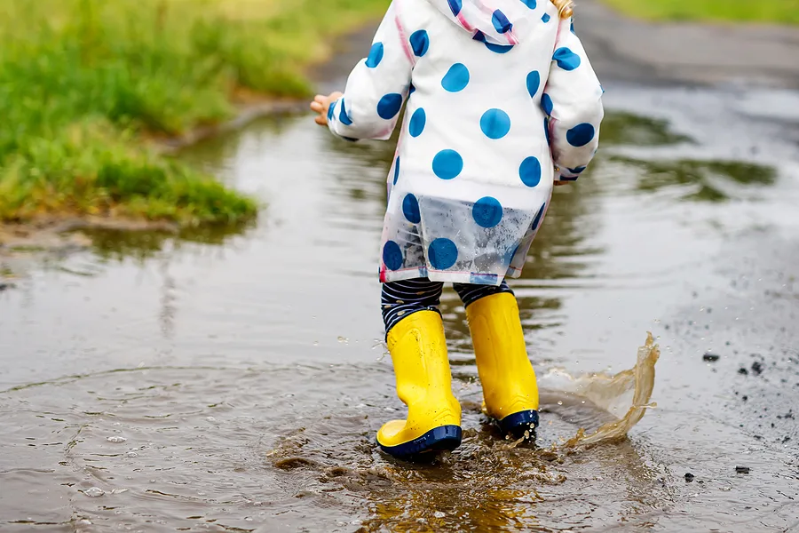 Child jumping in a puddle in the rain