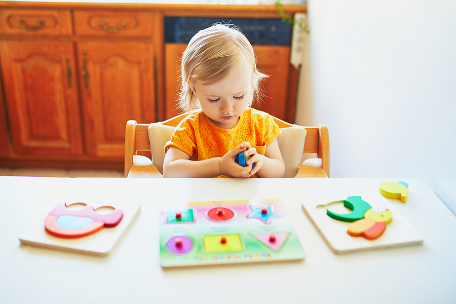 Child completing peg puzzles