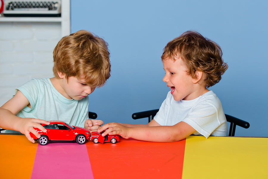 Children playing with red cars 