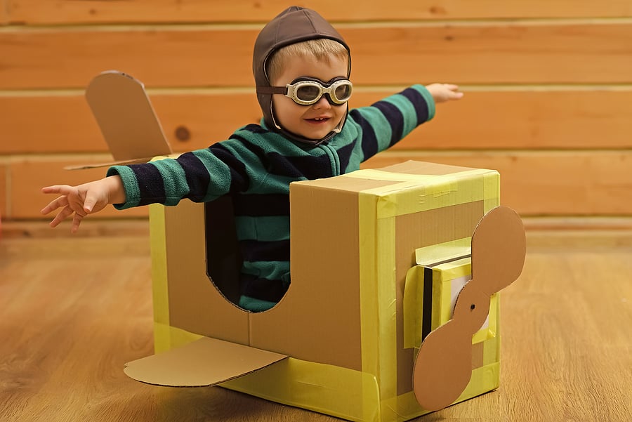 Child sitting in an airplane that looks like a box.