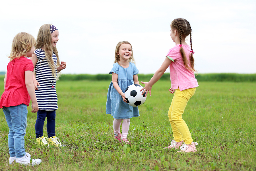 Children passing around a ball outside