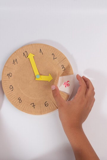 preschooler making a homemade clock