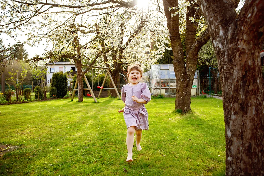 Girl running in a garden.