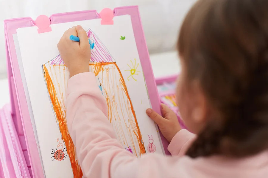 Little girl drawing a picture with markers