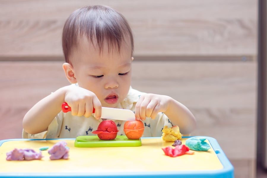 little child playing with playdough