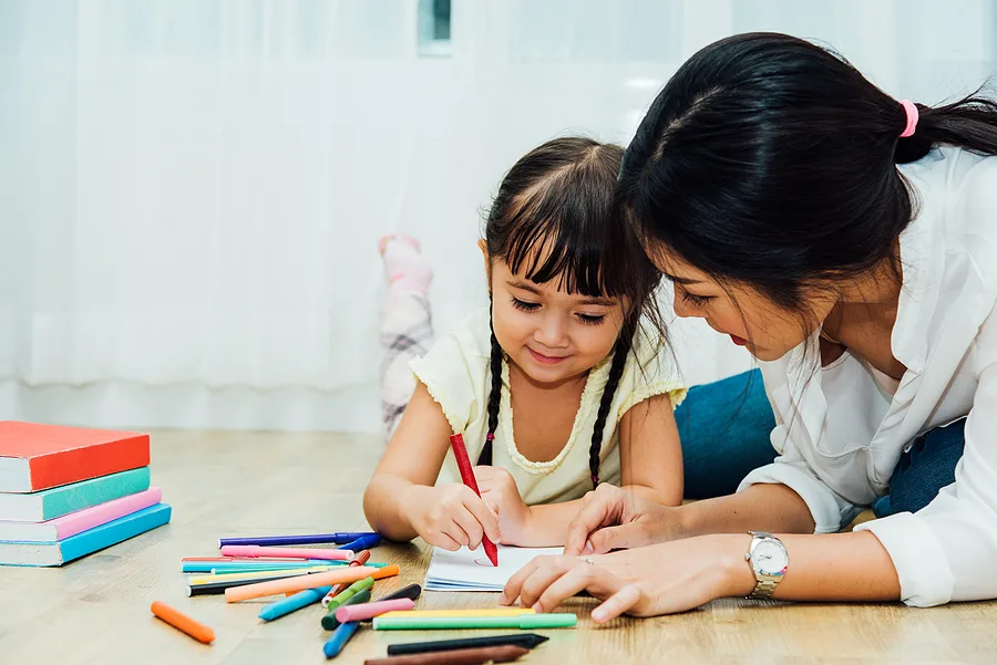 Mom talking to daughter while she draws.