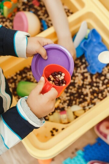 children playing with a sensory corn station