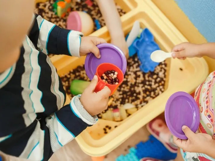 children playing with a sensory corn station