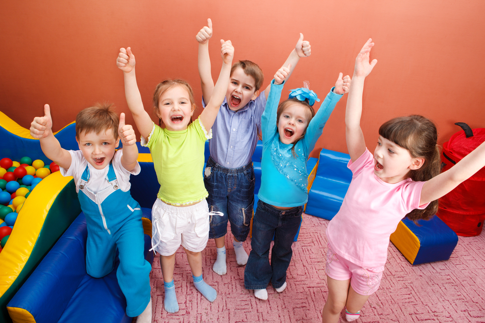 Group of children standing together and showing thumbs ups with both hands