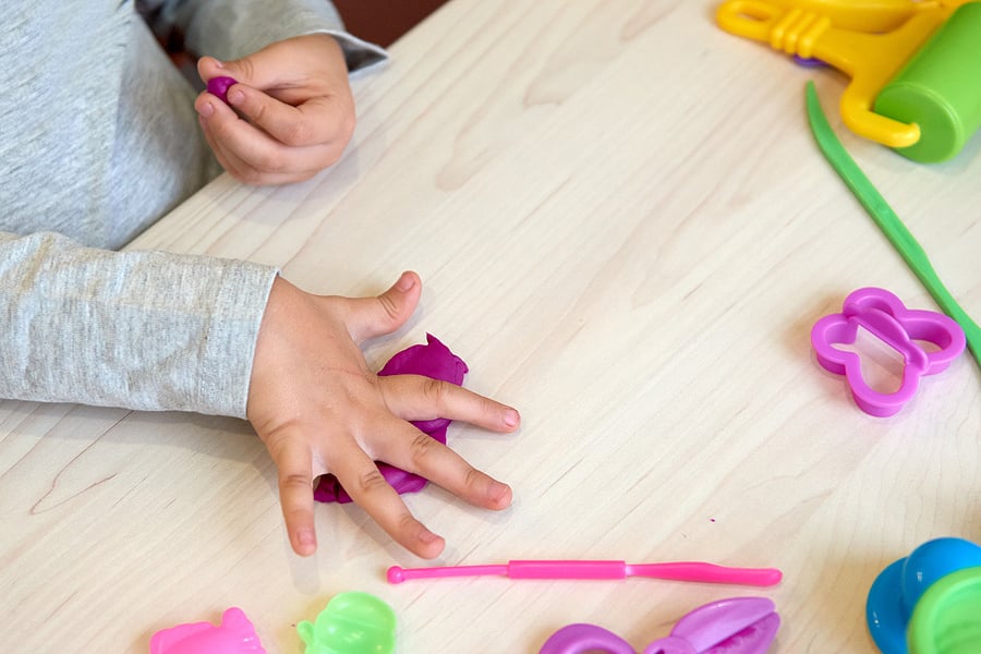 Child playing with playdough and cutters