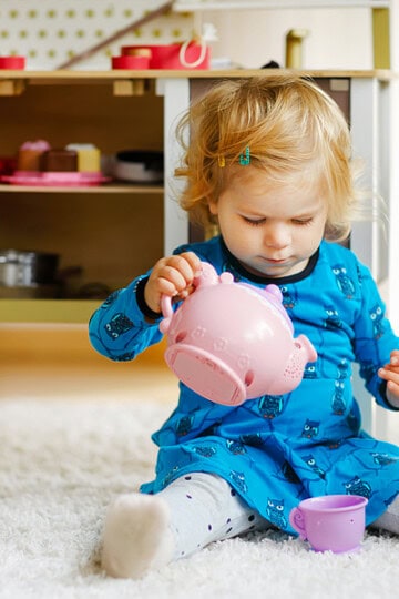little child making tea pretend play